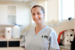 Investigadora de Agro Sustentable sonríe en laboratorio, representando el compromiso científico con la producción agrícola sustentable.