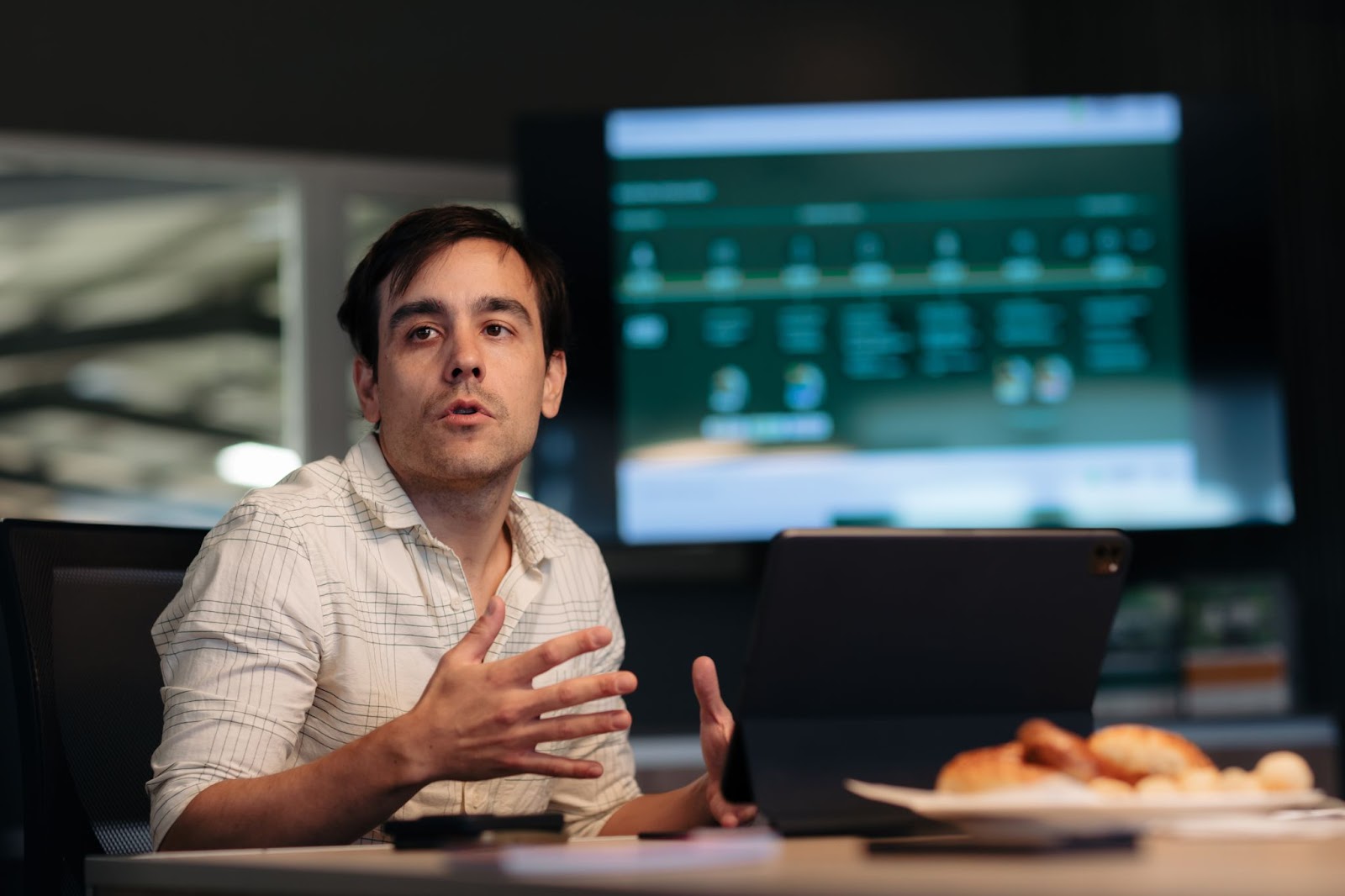 Matías Imperiale, cofundador de Agro Sustentable, participa de un evento de diálogo sobre sostenibilidad, sentado frente a una laptop con una presentación de fondo.