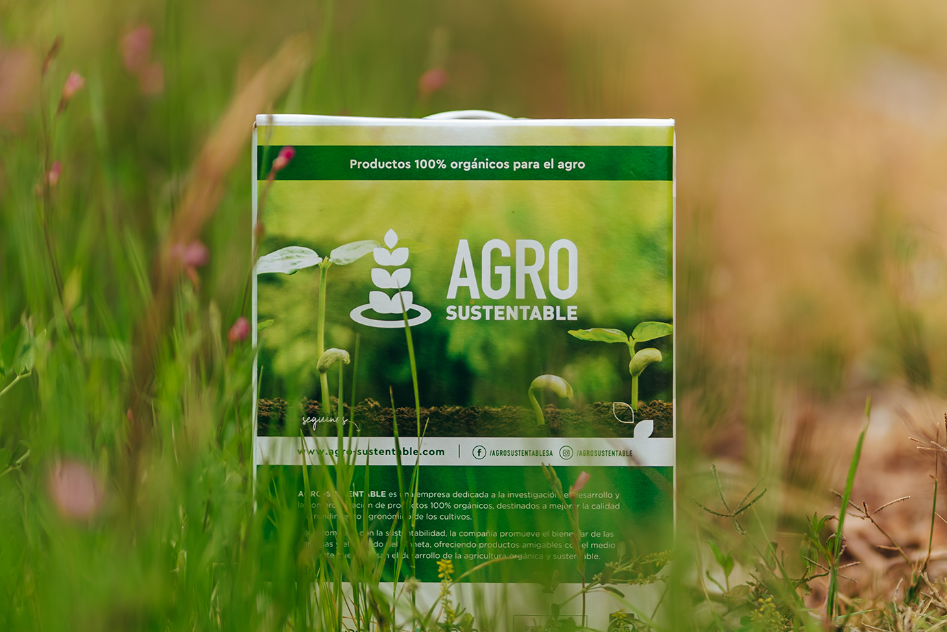 Envase de bioinsumo orgánico de Agro Sustentable (BIOFERT GTG X) en medio de un campo natural, rodeado de hierbas verdes.