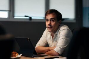 Matías Imperiale, sentado en una sala de reuniones, con una tablet frente a él y expresión atenta.